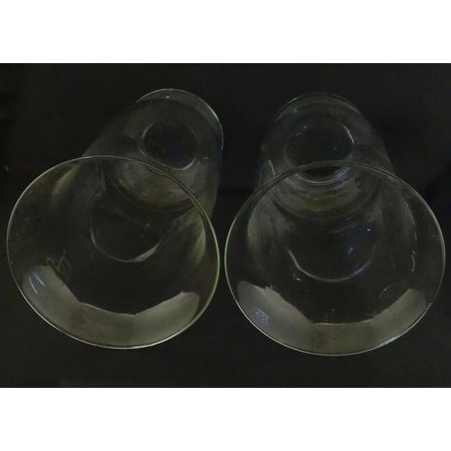 340 - A pair of clear glass storm lanterns with large candles, each approx 16