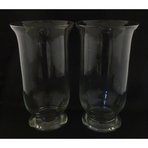 340 - A pair of clear glass storm lanterns with large candles, each approx 16