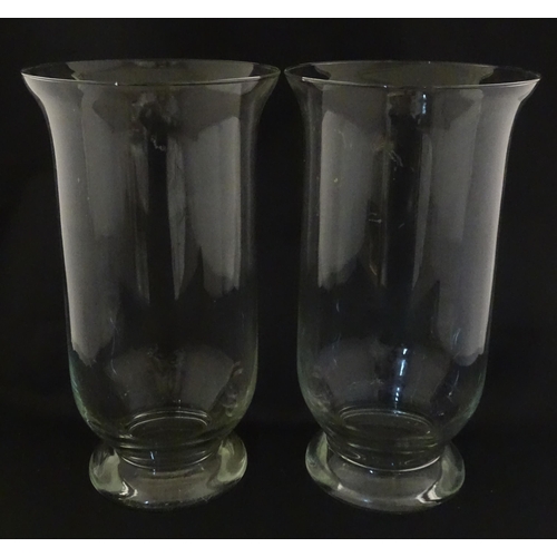 340 - A pair of clear glass storm lanterns with large candles, each approx 16