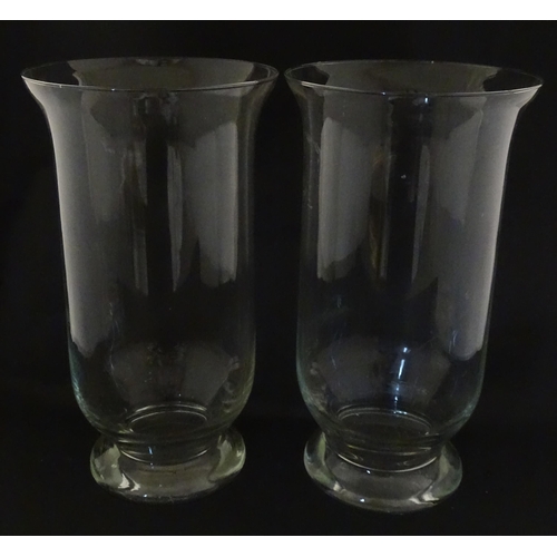 340 - A pair of clear glass storm lanterns with large candles, each approx 16