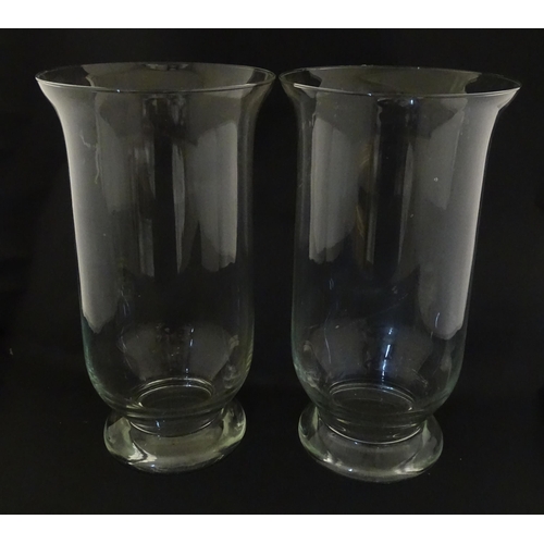 340 - A pair of clear glass storm lanterns with large candles, each approx 16