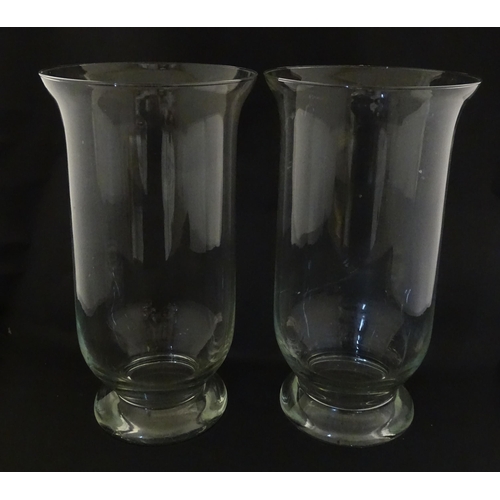 340 - A pair of clear glass storm lanterns with large candles, each approx 16