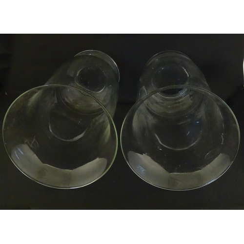 340 - A pair of clear glass storm lanterns with large candles, each approx 16