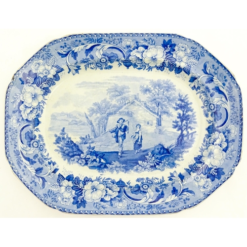 78 - A blue and white meat plate decorated in the Rural Scenery pattern with two figures in a country lan... 