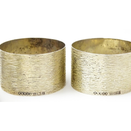 399 - Five assorted silver napkin rings to include a pair hallmarked Birmingham 1973, maker W I Broadway &... 