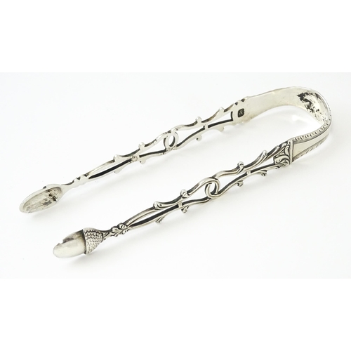 424 - 18thC silver sugar tongs with openwork decoration and acorn grips, maker W.C. Approx. 5 1/2