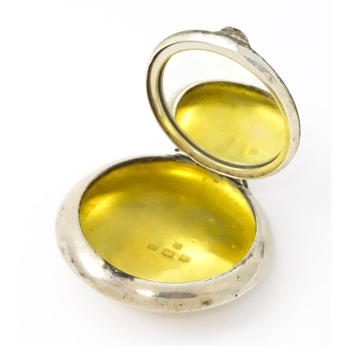 428 - A small silver compact / pill box with gilded interior and mirror within, hallmarked Birmingham 1920... 