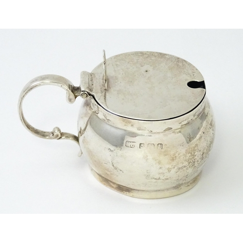 437 - A silver mustard pot with blue glass liner, hallmarked Birmingham 1918, maker George Unite & Sons. A... 