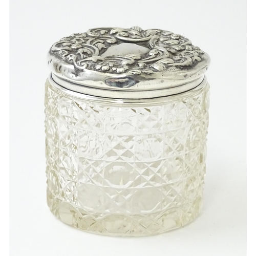 438 - A cut glass dressing table pot of cylindrical form with embossed silver lid hallmarked Birmingham 19... 