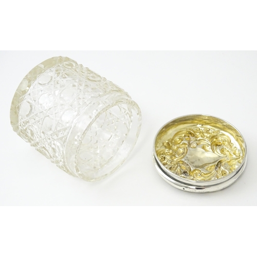 438 - A cut glass dressing table pot of cylindrical form with embossed silver lid hallmarked Birmingham 19... 