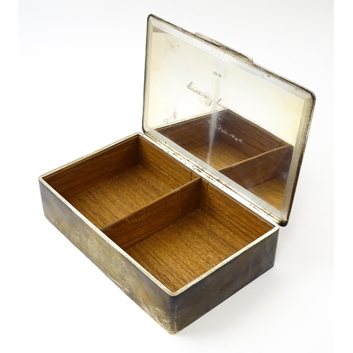 446 - An Art Deco silver cigarette box with engine turned decoration, opening to reveal a wood lined inter... 