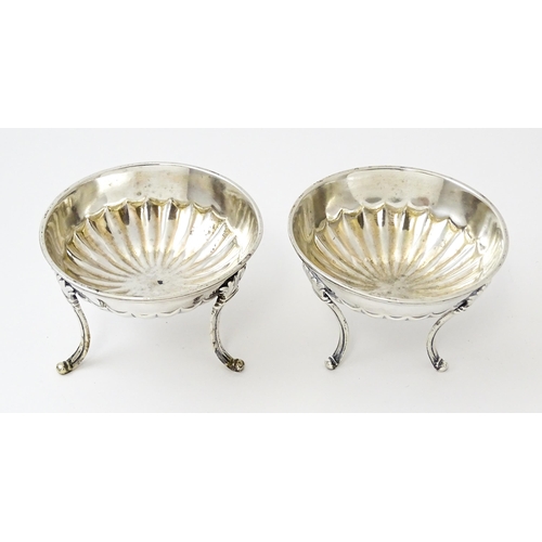 447 - A pair of unusual George III silver salts of circular form raised on three feet, hallmarked London 1... 