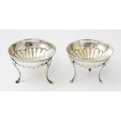 447 - A pair of unusual George III silver salts of circular form raised on three feet, hallmarked London 1... 