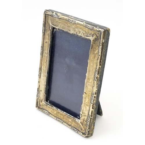 645 - An easel back photo frame with silver surround. Hallmarked Birmingham 1923 maker Green & Cadbury Ltd... 