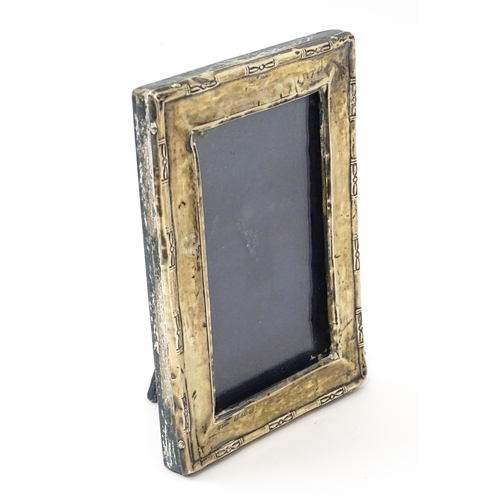 645 - An easel back photo frame with silver surround. Hallmarked Birmingham 1923 maker Green & Cadbury Ltd... 