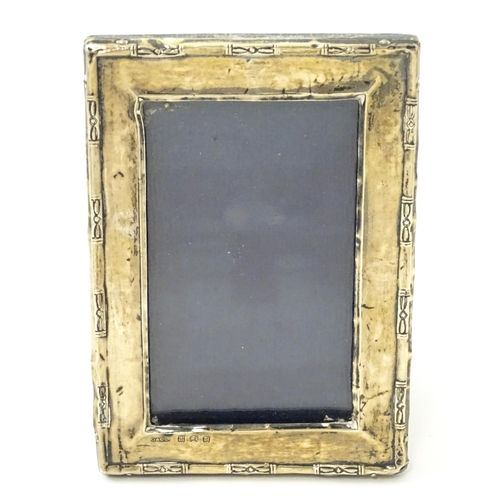 645 - An easel back photo frame with silver surround. Hallmarked Birmingham 1923 maker Green & Cadbury Ltd... 