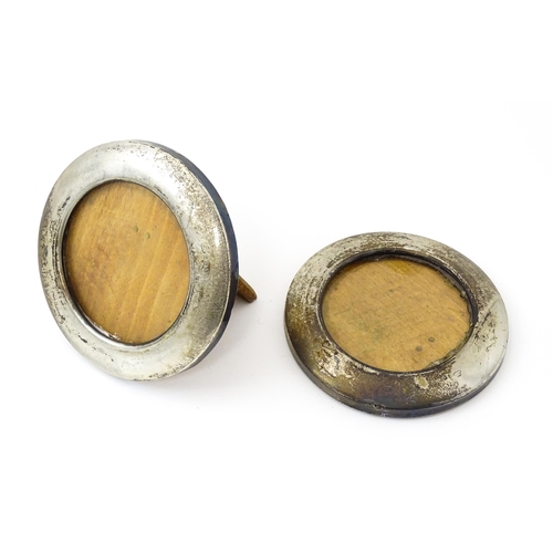 646 - A pair of photograph frames of circular form with silver surrounds, hallmarked London 1918. Approx. ... 