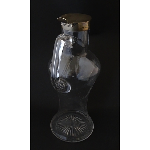 281 - A Victorian glass claret jug with loop handle and silver lid hallmarked London 1894, maker Hukin & H... 