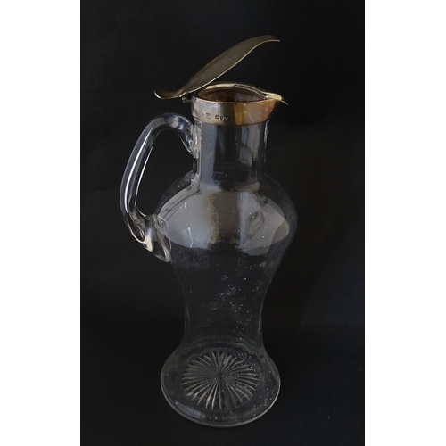 281 - A Victorian glass claret jug with loop handle and silver lid hallmarked London 1894, maker Hukin & H... 