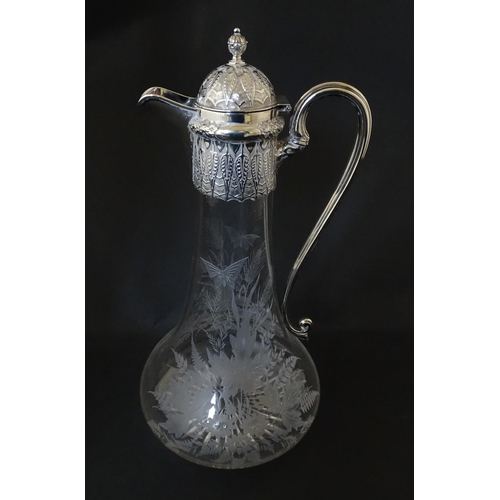 308 - A Victorian glass claret jug with etched floral, foliate and butterfly detail to body, having a silv... 