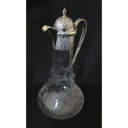 308 - A Victorian glass claret jug with etched floral, foliate and butterfly detail to body, having a silv... 