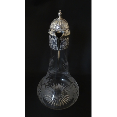 308 - A Victorian glass claret jug with etched floral, foliate and butterfly detail to body, having a silv... 