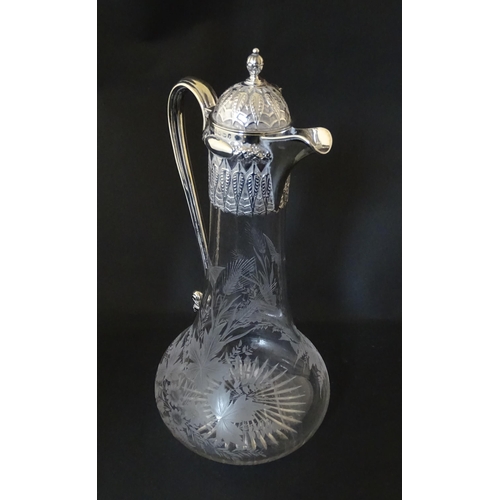 308 - A Victorian glass claret jug with etched floral, foliate and butterfly detail to body, having a silv... 