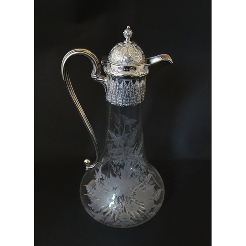 308 - A Victorian glass claret jug with etched floral, foliate and butterfly detail to body, having a silv... 