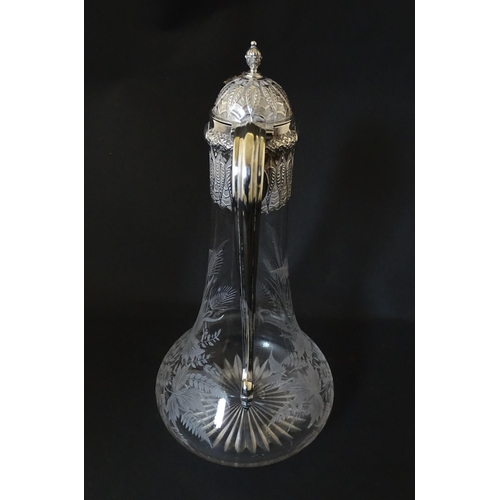 308 - A Victorian glass claret jug with etched floral, foliate and butterfly detail to body, having a silv... 