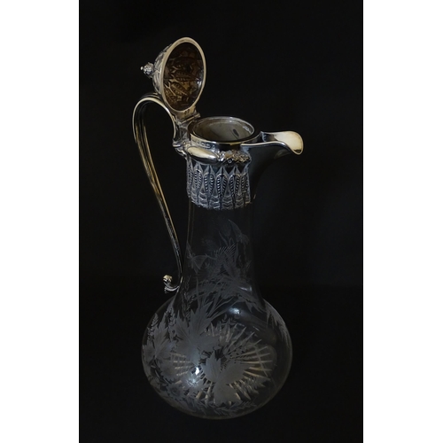 308 - A Victorian glass claret jug with etched floral, foliate and butterfly detail to body, having a silv... 