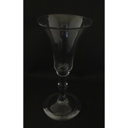 321 - A Georgian drinking glass with flared rim, folded foot and knop to stem. Approx. 6 1/4