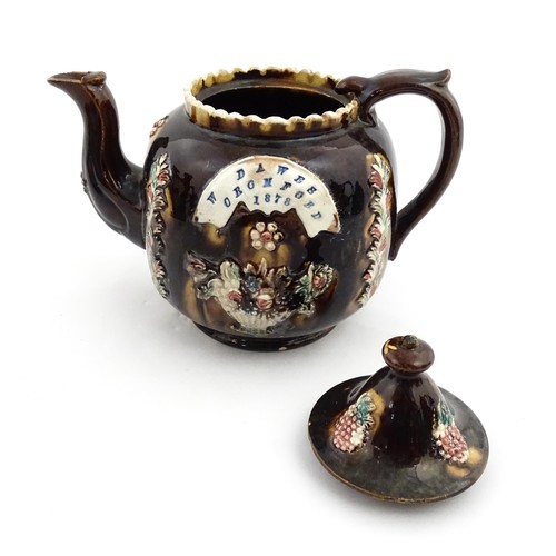 218 - A Victorian Measham bargeware Toby / Character teapot bearing a plaque titled W Dawes Cromford 1878,... 