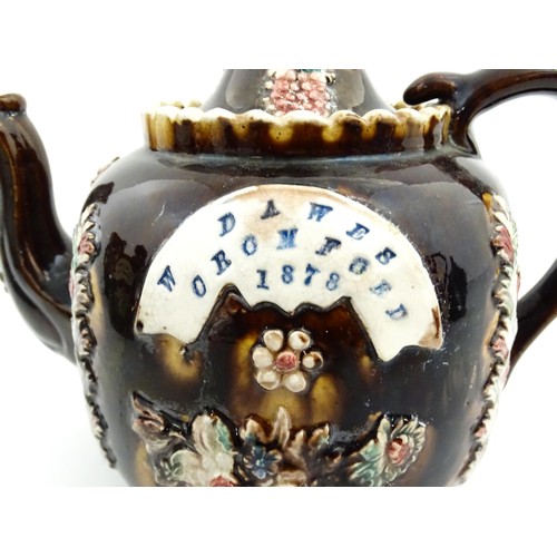 218 - A Victorian Measham bargeware Toby / Character teapot bearing a plaque titled W Dawes Cromford 1878,... 