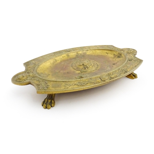 1210 - A 19thC French gilt brass dish / stand of shaped form raised on four lion paw feet, decorated with l... 