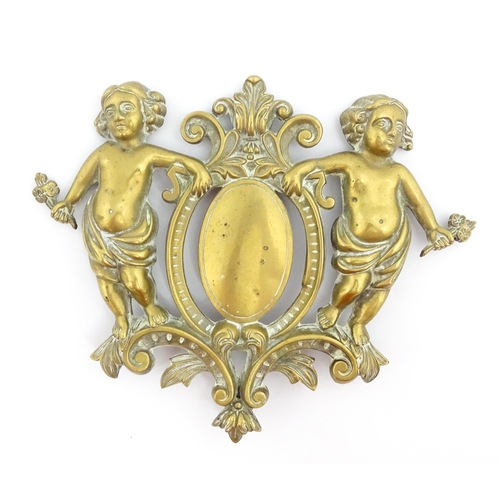 1218 - A late 19th / early 20thC cast brass plaque / mount formed as a cartouche flanked by two cherubs / p... 