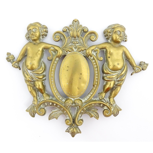 1218 - A late 19th / early 20thC cast brass plaque / mount formed as a cartouche flanked by two cherubs / p... 