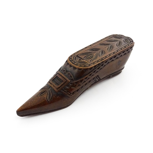 1371 - Treen : A large 19thC Continental shoe snuff box with sliding lid, and chip carved decoration with f... 