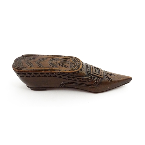 1371 - Treen : A large 19thC Continental shoe snuff box with sliding lid, and chip carved decoration with f... 