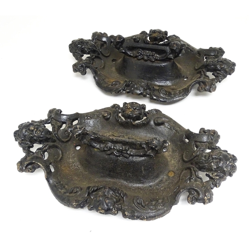 1585 - A pair of cast iron boot scrapers with acanthus and mask decoration, in black painted finish. Each a... 