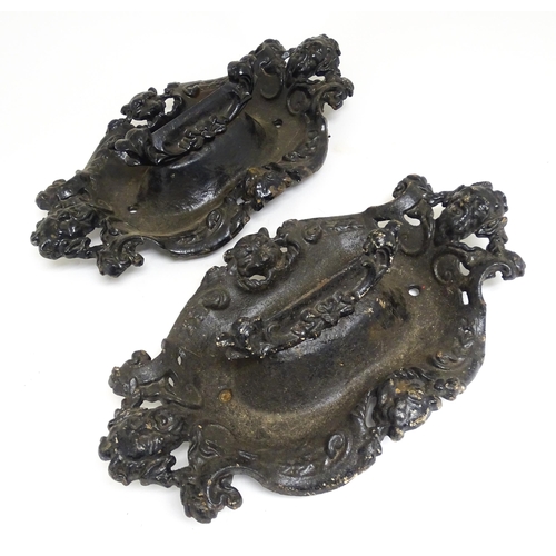 1585 - A pair of cast iron boot scrapers with acanthus and mask decoration, in black painted finish. Each a... 