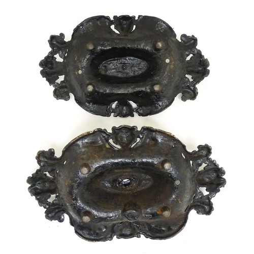 1585 - A pair of cast iron boot scrapers with acanthus and mask decoration, in black painted finish. Each a... 