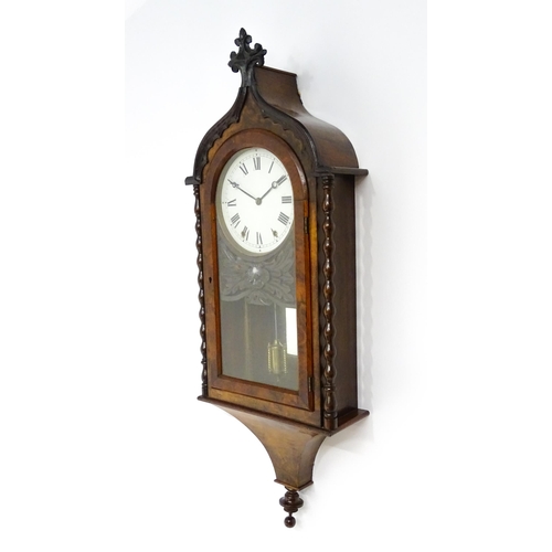 1656 - A Victorian 8-day wall clock, the walnut veneered case with twist columns surmounted by a cross form... 