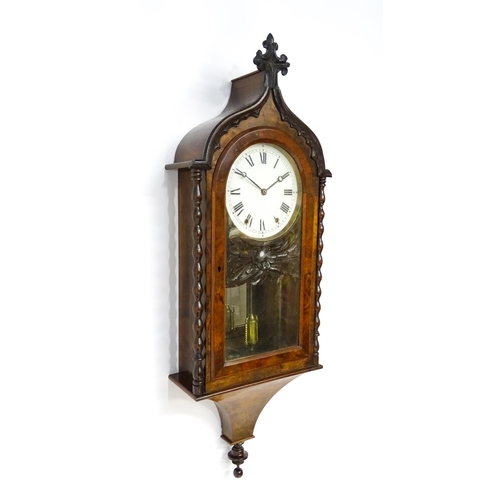 1656 - A Victorian 8-day wall clock, the walnut veneered case with twist columns surmounted by a cross form... 