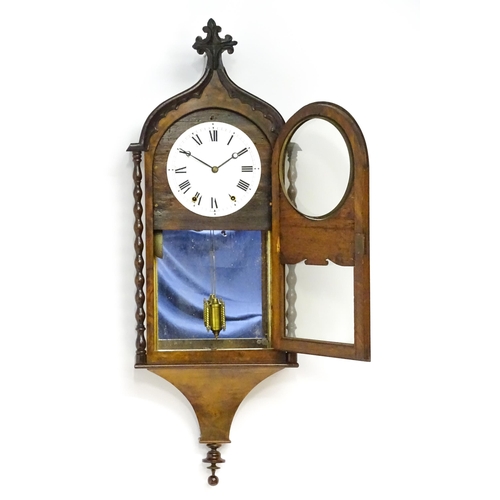 1656 - A Victorian 8-day wall clock, the walnut veneered case with twist columns surmounted by a cross form... 