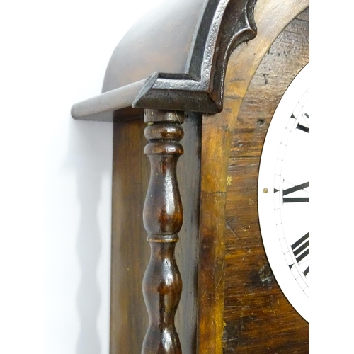 1656 - A Victorian 8-day wall clock, the walnut veneered case with twist columns surmounted by a cross form... 