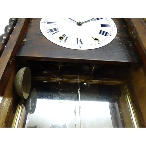 1656 - A Victorian 8-day wall clock, the walnut veneered case with twist columns surmounted by a cross form... 