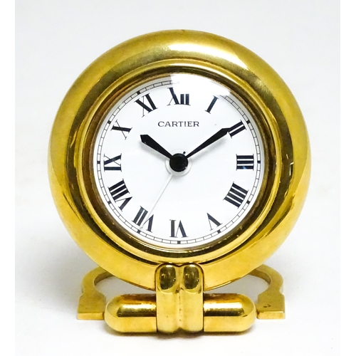 1658 - A Cartier brass cased alarm clock with quartz movement, the white dial with Roman numerals and signe... 