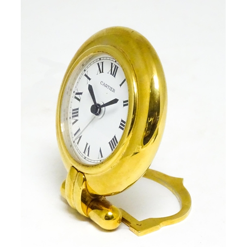 1658 - A Cartier brass cased alarm clock with quartz movement, the white dial with Roman numerals and signe... 