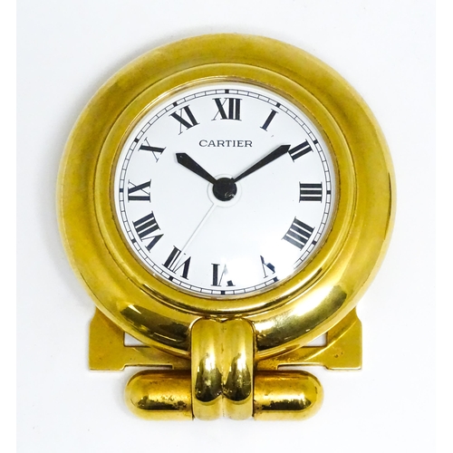 1658 - A Cartier brass cased alarm clock with quartz movement, the white dial with Roman numerals and signe... 