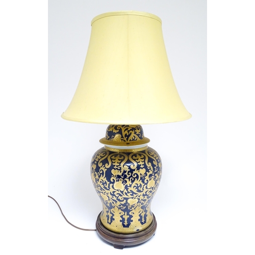 1671 - A large 20thC table lamp formed as a Chinese jar and cover, the blue ground with gilt floral and fol... 